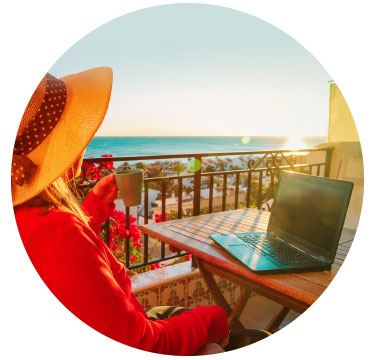 Frau mit Laptop und Blick aufs Meer - Workation