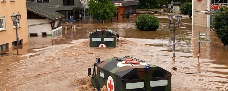 Überschwämmte Straße. Bundeswehrfahrzeuge im Hochwasser