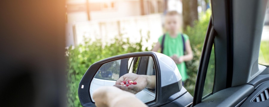 Mann bietet Jungen aus dem Auto Süßigkeiten an