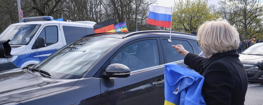 Pro-russischer Autokorso mit Russlandfahne und Gegendemonstrantin mit Ukraine-Fahne